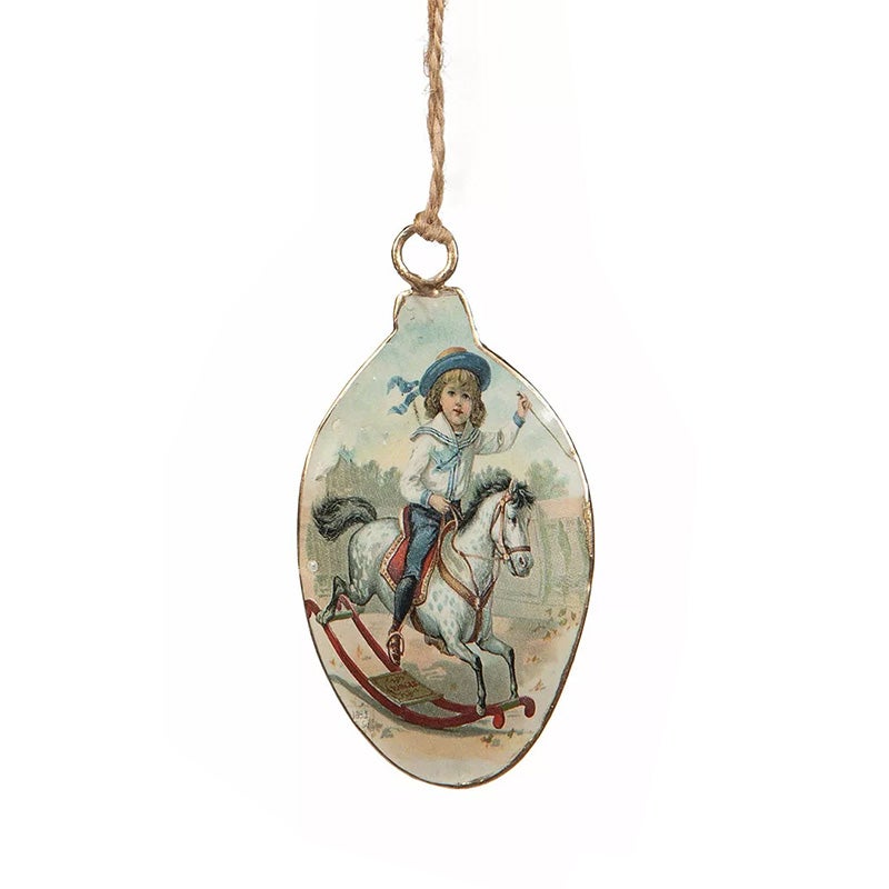 Ovaalin muotoinen  emaliriipus, poika ja keinu